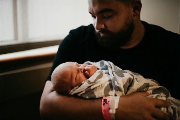 Black man holding newborn